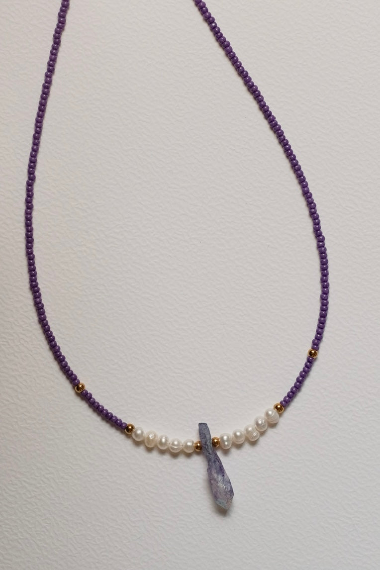 Purple beaded necklace with fresh water pearls and a natural crystal pendant