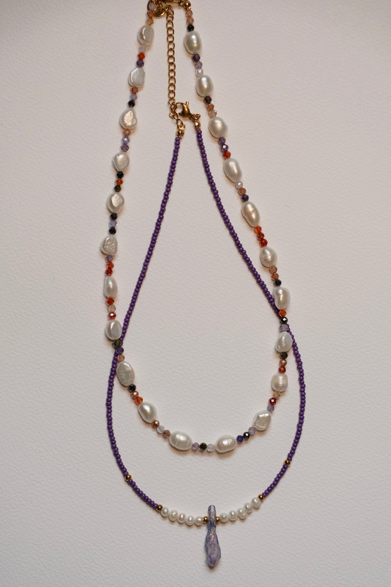 Purple beaded necklace with fresh water pearls and a natural crystal pendant